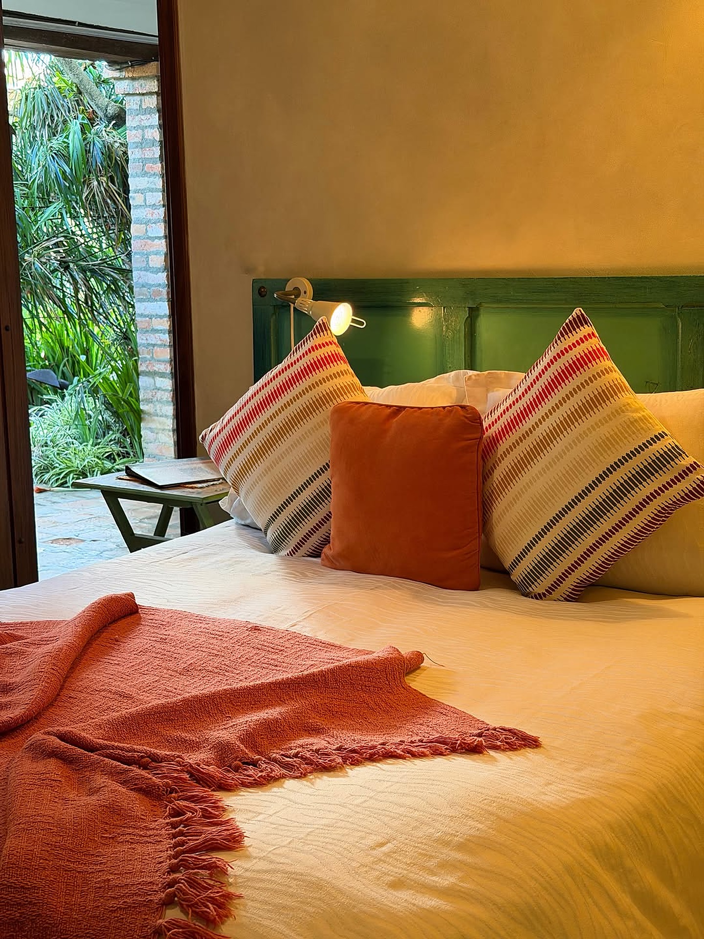 Cama con cojines tejidos y manta